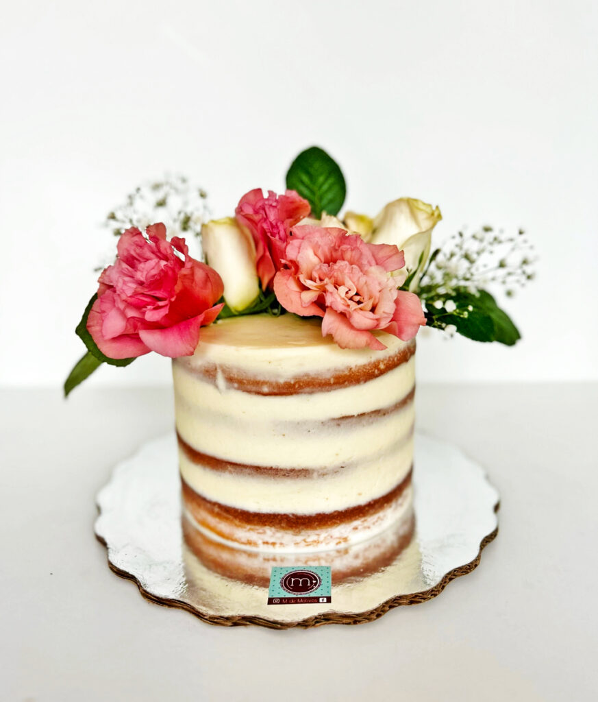 Un pastel de un vido estilo "desnudo" con ligera cobertura de betún. Los pasteles de boda de este estilo son muy populares por decoraciones sencillas con flores.