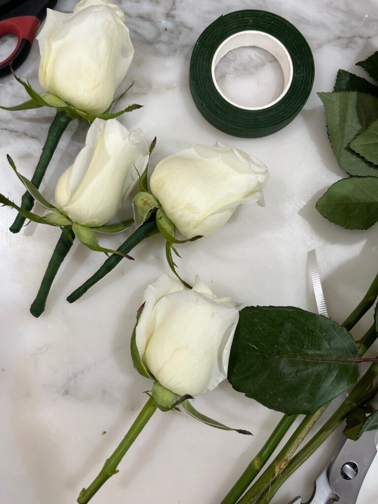 Un grupo de flores cubiertas en el tallo con floratape. Los diseños de pasteles para bodas con flores requieren cuidados para asegurar la higiene de las flores y el pastel.