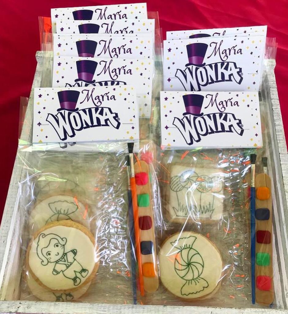 Un set de galletas con una barra de colores para que los niños puedan tener sus propias galletas decoradas por ellos mismos. Estas galletas están preparadas para entregarse en una fiesta infantil que tiene temática del personaje "Wonka". Las galletas se colocan dentro de bolsas de celofan transparente.