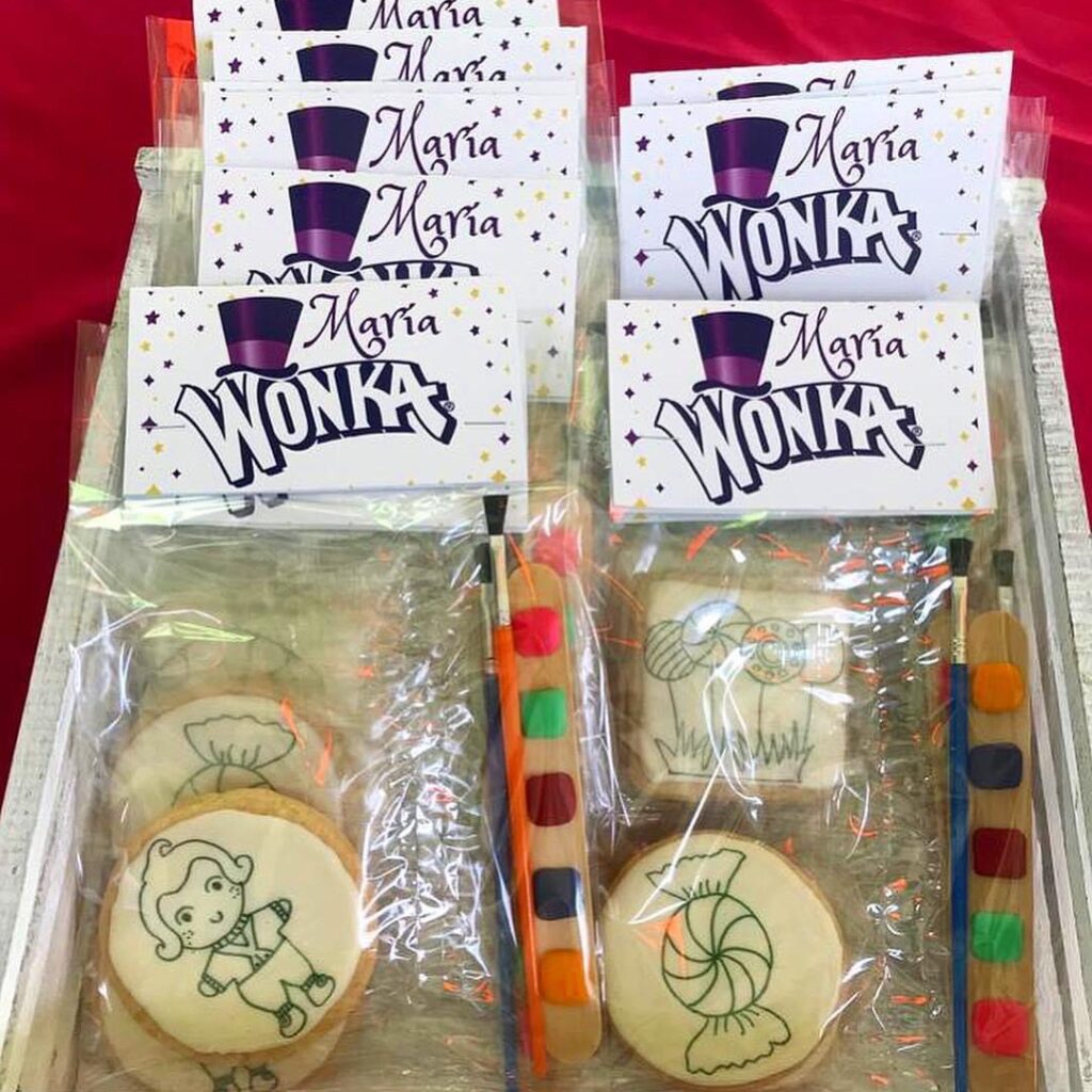 Un set de galletas con una barra de colores para que los niños puedan tener sus propias galletas decoradas por ellos mismos. Estas galletas están preparadas para entregarse en una fiesta infantil que tiene temática del personaje "Wonka". Las galletas se colocan dentro de bolsas de celofan transparente.