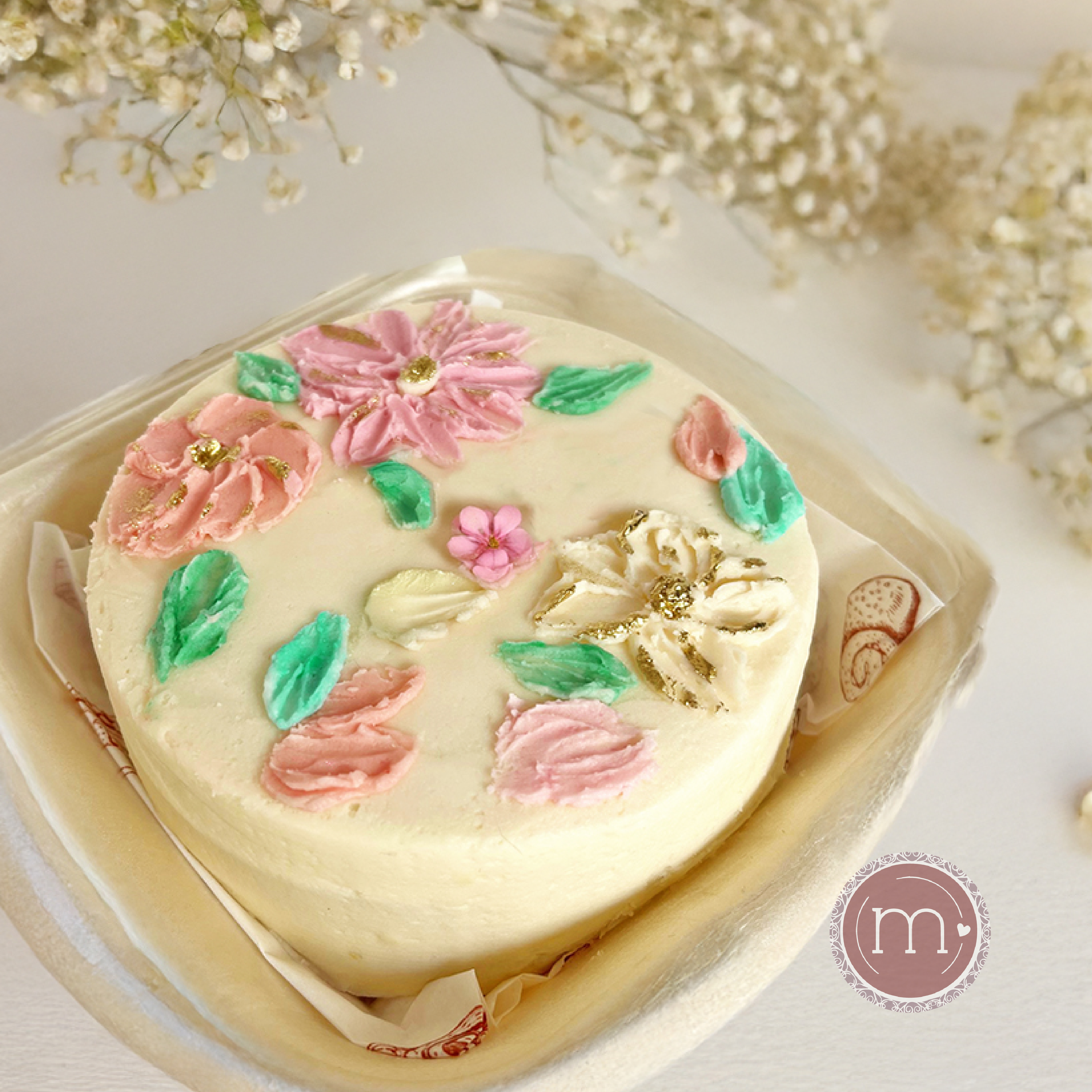 Un mini pastel decorado con betún blanco y detalles de flores con betún. Para las bodas en Puebla los pasteles mini son tendencia para ofrecerse para cada invitado. El pastel se coloca en un recipiente blanco sobre un mantel de color blanco.
