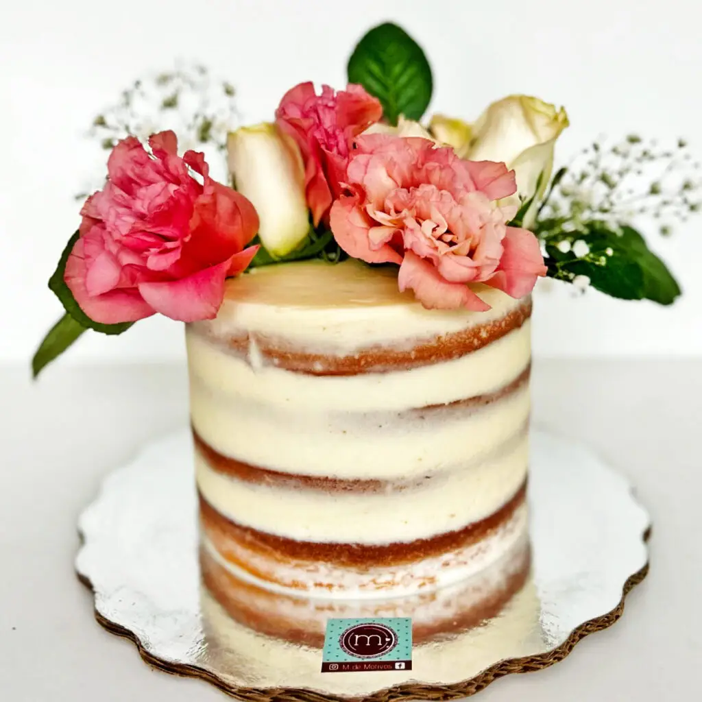 Pasteles de boda estilo simbólico decorados con flores naturales. El pastel se coloca sobre una base plateada reflectante