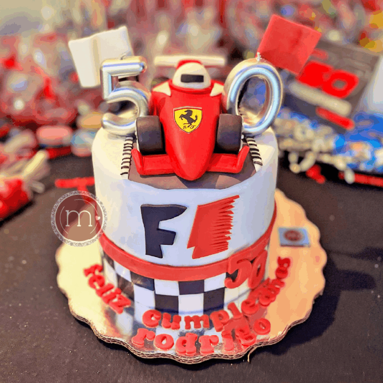 Un pastel redondo que en la parte frontal tiene la palabra "F1" y está decorado con temática de la "Fórmula 1". En la parte superior se coloca un auto de carreras hecho de fondant. Los pasteles fondant personalizados son el atractivo de una fiesta temática.