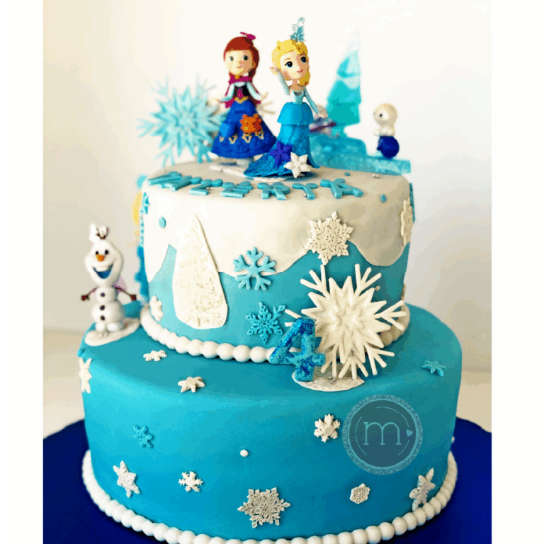 Los pasteles fondant destacan por decoraciones como este pastel de cumpleaños azul de dos niveles decorado con copos de nieve blancos y personajes de la película animada "Frozen". El nivel superior presenta figuras de dos personajes femeninos, mientras que el nivel inferior tiene la figura de un muñeco de nieve. Varias decoraciones de temática invernal adornan este pasteles fondant.