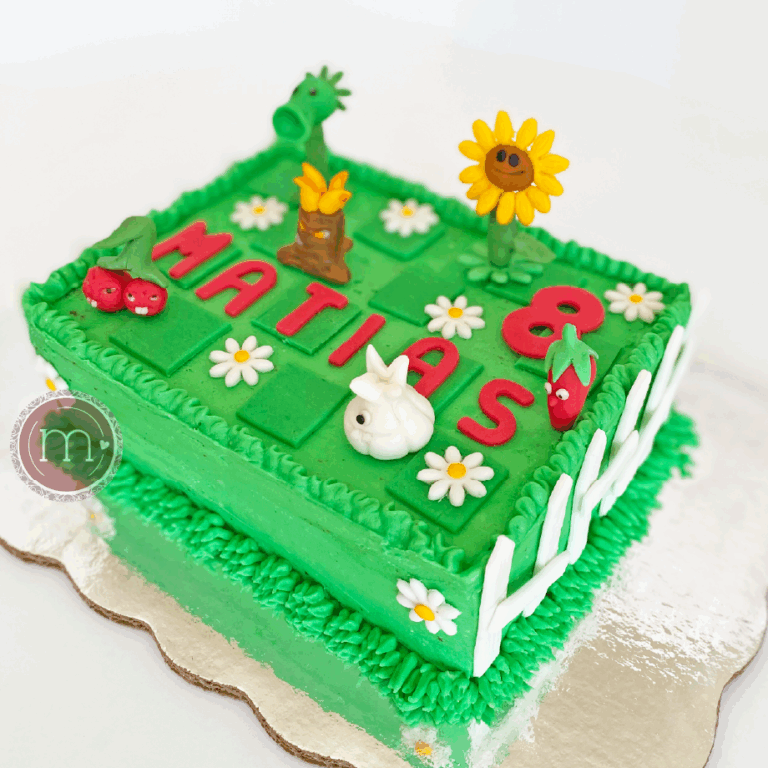 Un pastel de forma rectangular con una temática del videojuego "Plants vs Zombies". Los pasteles fondant decorados con temáticas de videojuegos son muy populares. El pastel se coloca sobre una base plateada reflectante.