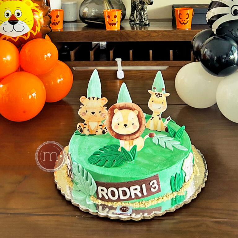 Este es un hermoso pastel infantil decorado con temática de animales de la selva y naturaleza, ideal para celebrar un cumpleaños. Está adornado con figuras de animales como un león, un tigre y una jirafa, en colores vibrantes y rodeado de hojas y elementos naturales. El pastel lleva el mensaje "RODRI 3" y está decorado con detalles creativos en fondant o papel comestible. En el fondo, también se pueden ver globos naranjas, blancos, negros y una figura de globo con un león, creando un ambiente festivo y alegre. Este pastel es un ejemplo perfecto de pasteles personalizados para cumpleaños infantiles, diseñados para sorprender y encantar a los pequeños festejados y a sus invitados.