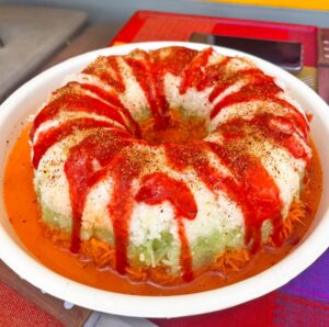 Botana para la noche mexicana, rosca de verdura hecha de zanahoria, pepino y jícama. La rosca está bañada con salsa de chamoy y chile tajín. En m de motivos repostería personalizada de Puebla se hacen estos postres botaneros.