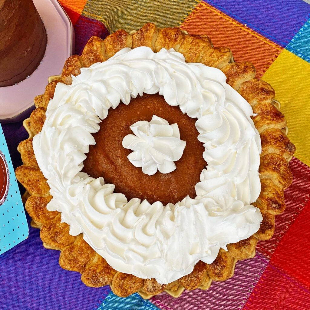 Un pay de calabaza es de los postres de otoño calasico. M de otoño, repostería personalizada en puebla vende este postre otoñal. El pie se coloca sobre un mante de tela de colores.