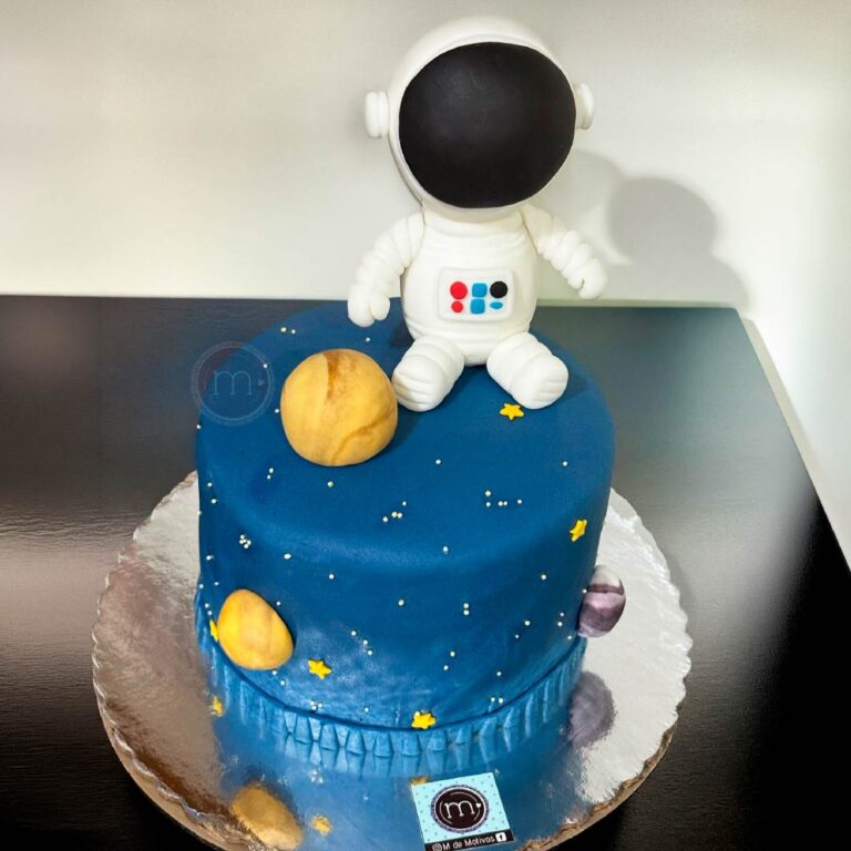 Un pastel fondant de astronauta. Pastel de color azul decorado con una figura de astronauta hecha de fondant. Se coloca sobre una base reflectante. Pastel hecho en puebla por m de motivos.