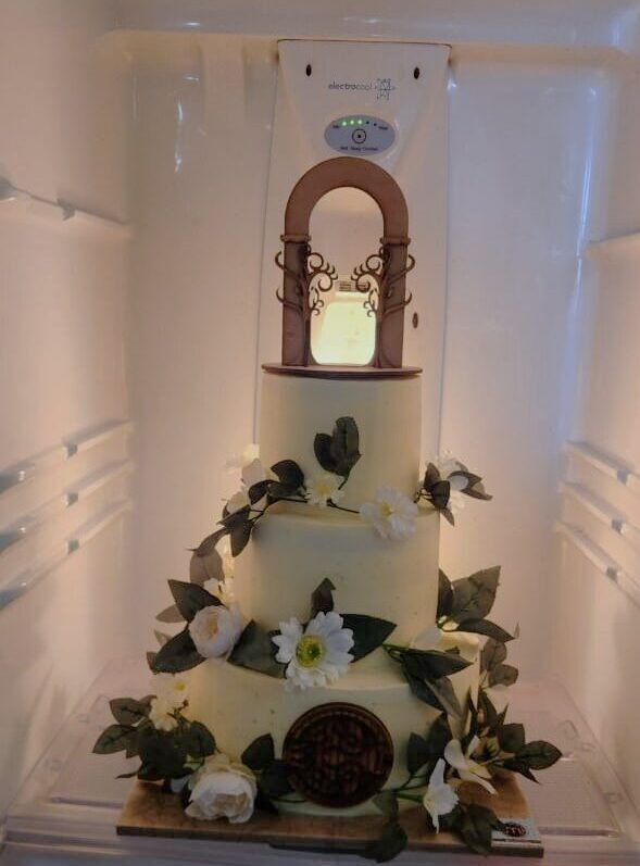 Un pastel de color blanco decorado con hojas naturales de color verde. Pasteles personalizados puebla para boda. El pastel se coloca en un refrigerador.